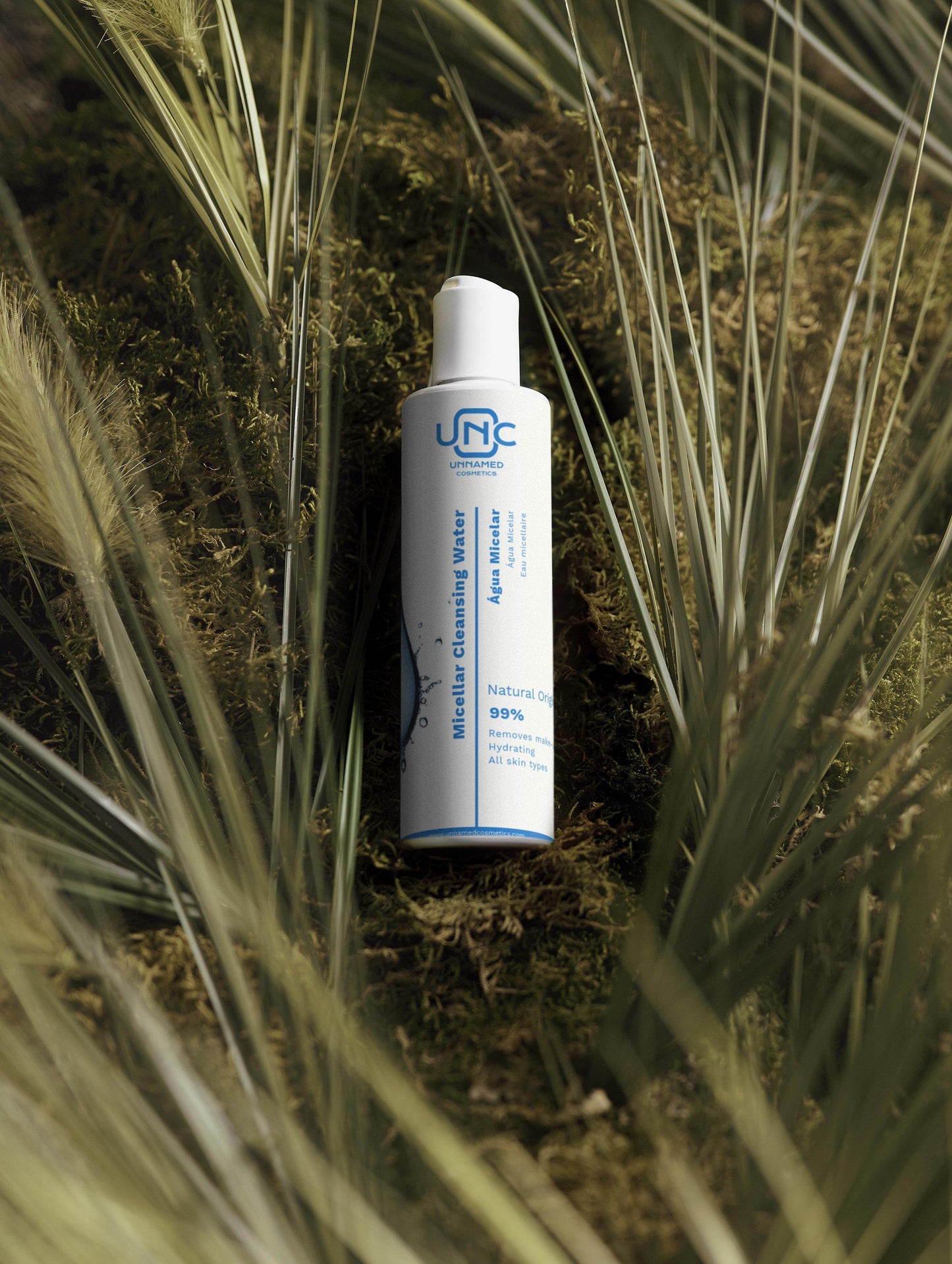 Frasco branco de agua micelar natural da Unnamed Cosmetics em ambiente com plantas secas