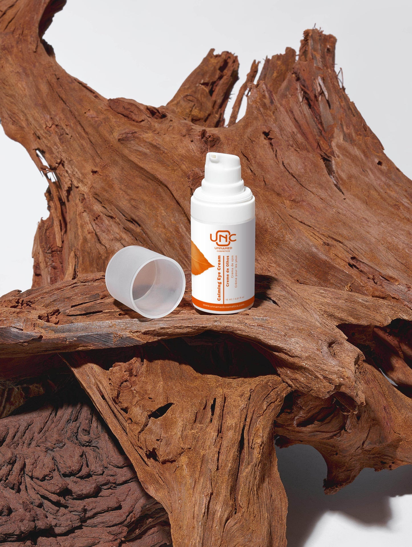 Frasco branco de creme para olhos calmante da Unnamed Cosmetics sobre madeira natural texturizada
