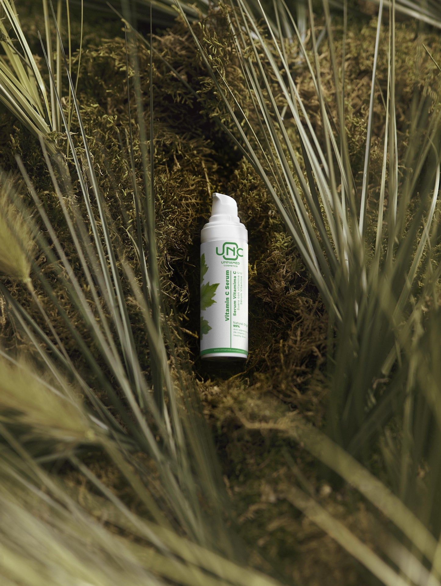 Sérum facial com vitamina C eficaz em embalagem branca com detalhes verdes sobre musgo natural
